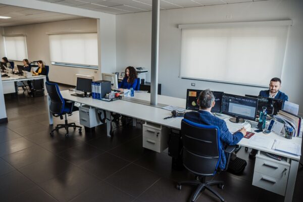 Dipendenti in riunione presso scrivania centrale