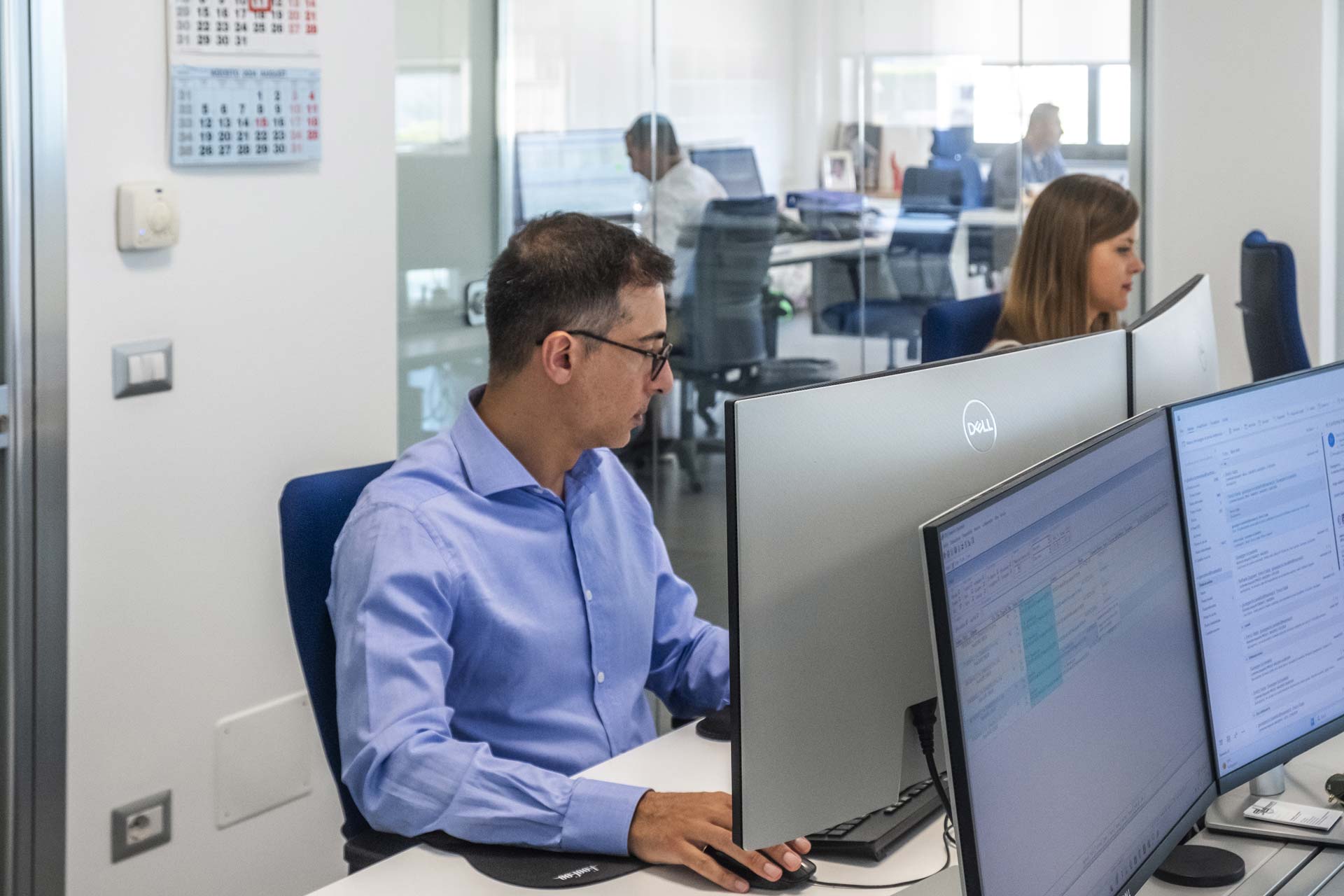 Impiegato con camicia azzurra davanti al PC