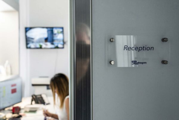 Insegna “Reception” su porta in vetro
